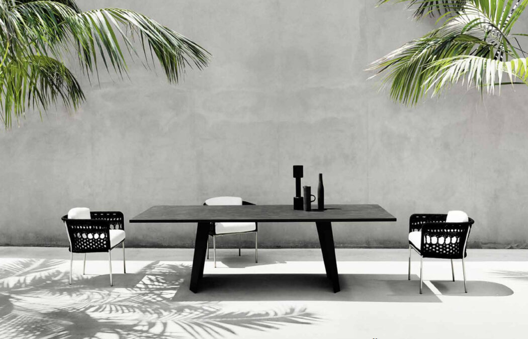 Tisch mit Stühlen vor grauer Wand